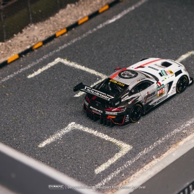 Modelo de carrinho de corrida branco e preto num parque de estacionamento em miniatura