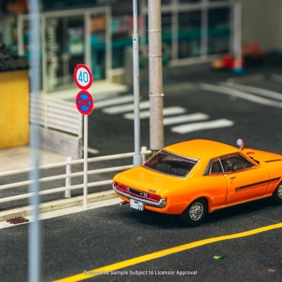 Carro modelo antigo laranja numa rua com sinais de trânsito