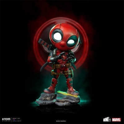 Figura colecionável de Deadpool com traje vermelho e preto e base rochosa.