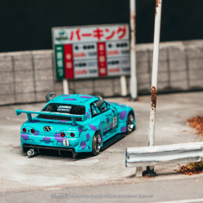 Modelo de carro de brinquedo azul com manchas roxas e spoiler em mini parque de estacionamento.