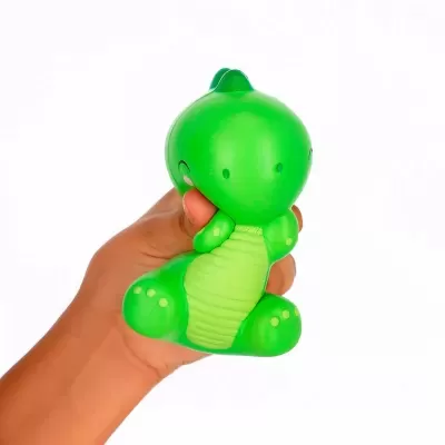 Brinquedo de stress dinossauro verde segurado por uma mão
