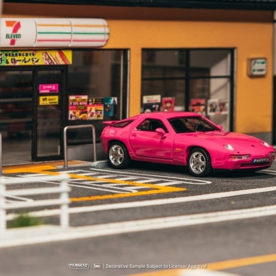 Carro cor-de-rosa estacionado em frente a loja 7-Eleven com portas de vidro e cartazes