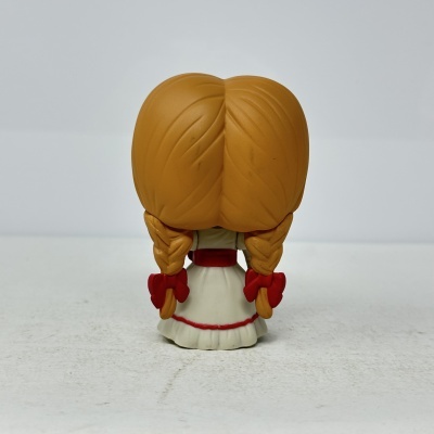 Figura de brinquedo com vestido branco e cabelo em tranças vistas de costas