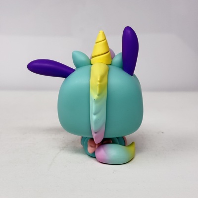 Figura de vinil de unicórnio azul com chifre amarelo e orelhas roxas vista de trás