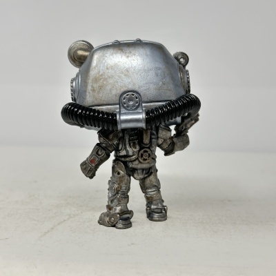 Figura colecionável de robô prateado com tubos pretos e armadura desgastada