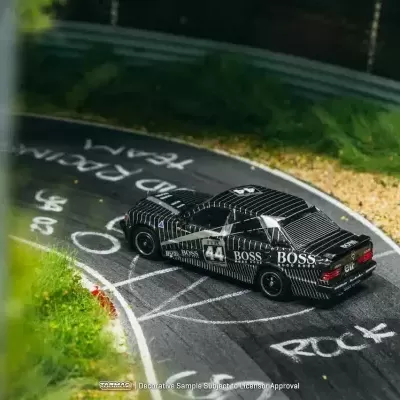 Carro de corrida miniatura preto com riscas brancas e BOSS na pista curva