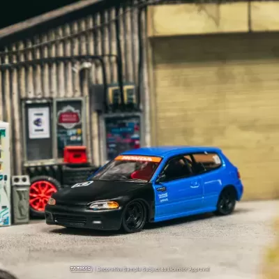 Carro modelo em miniatura azul e preto num cenário urbano em miniatura