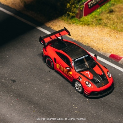 Miniatura de carro de corrida vermelho e preto com texto PORSCHE e PIRELLI na pista