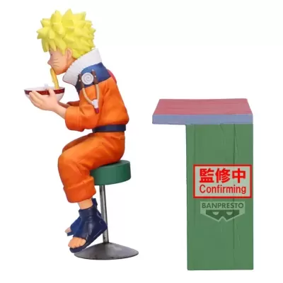 Figura colecionável personagem anime a comer ramen sentado num banco, com mesa ao lado