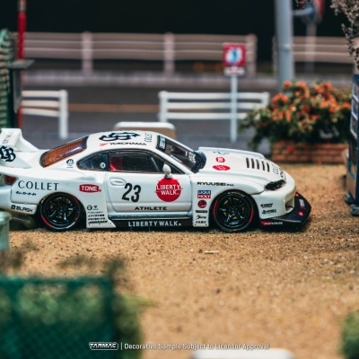 Miniatura de carro de corrida branco com várias inscrições num cenário urbano