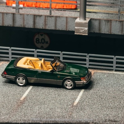 Miniatura de carro conversível verde com interior amarelo num parque de estacionamento