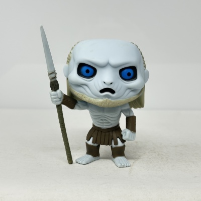 Figura de brinquedo com olhos azuis e roupa castanha segurando arma comprida