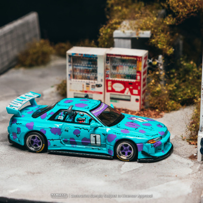 Miniatura de carro de corrida azul com manchas roxas e número 1, junto a dois dispensadores de bebidas automáticos.