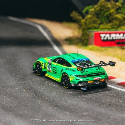 Modelo de carro de corrida verde com insígnias na pista de corrida