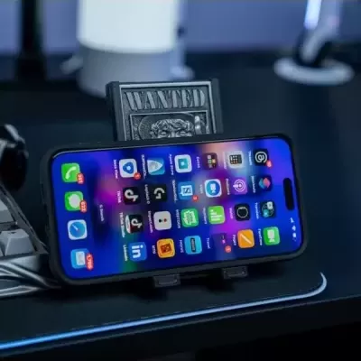 Smartphone colocado numa base de suporte preta com a palavra WANTED ao fundo