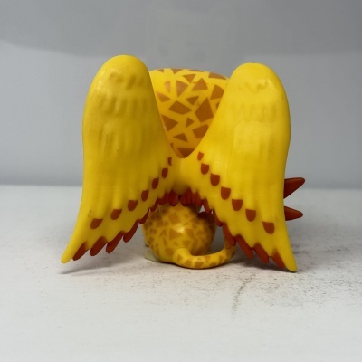 Figura de brinquedo amarelo com asas grandes amarelas vista de trás