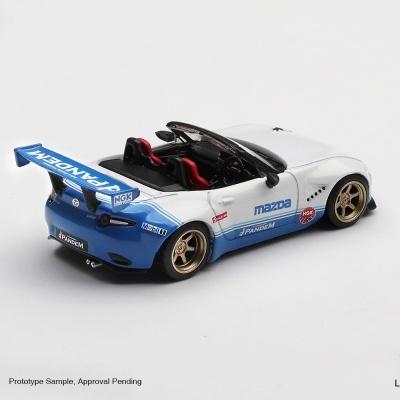 Miniatura de carrro desportivo Mazda branco e azul com spoiler traseiro azul e jantes douradas.