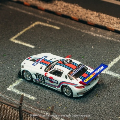Miniatura de carro de corrida branco com faixas azuis e vermelhas e texto MARTINI numa mini pista