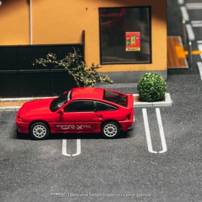 Carro desportivo vermelho estacionado em lugar marcado junto a parede amarela