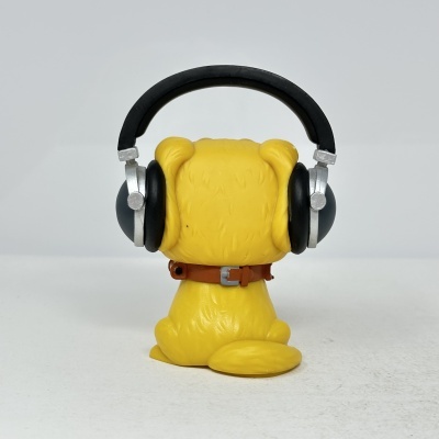 Figura de cão amarelo de costas com auscultadores pretos e colar castanho