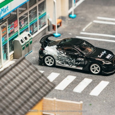 Miniatura de carro desportivo preto junto a loja FamilyMart