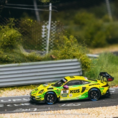Miniatura de carro de corrida Porsche 911 amarelo e verde em mini pista de corrida com vegetação