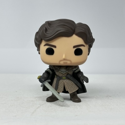 Figura Funko Pop vestida de armadura com espada em superfície branca