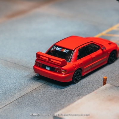 Miniatura de carro desportivo vermelho com texto RALLI ART na janela traseira