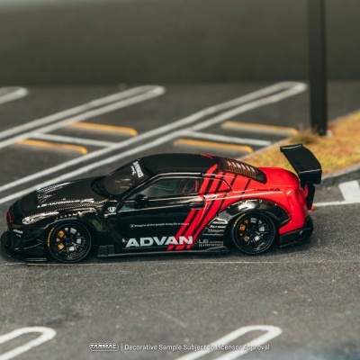Miniatura de carro desportivo preto e vermelho com textos ADVAN e LB Works em estrada de estacionamento