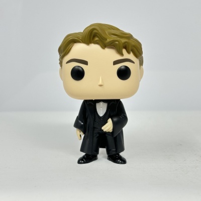 Figura Funko Pop de cabelo castanho e fato preto em fundo branco