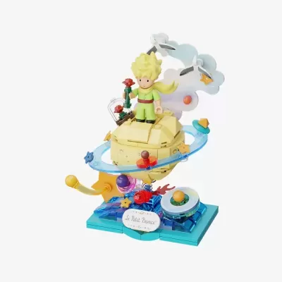 Figura LEGO do Pequeno Príncipe com planeta amarelo e anéis azuis sobre base azul.