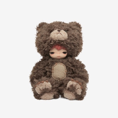 Boneco com roupa de urso castanho e rosto humano visível