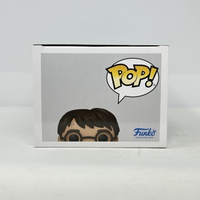 Caixa de brinquedo Funko Pop com imagem parcial de figura com cabelo castanho e óculos redondos