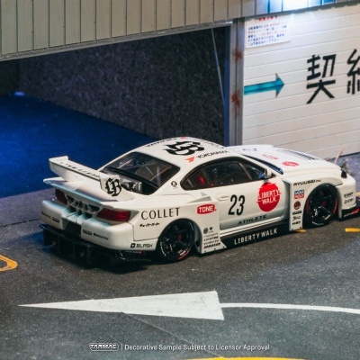 Carro de corrida miniatura branco com logótipos e adesivos coloridos num cenário de pista de corrida em miniatura