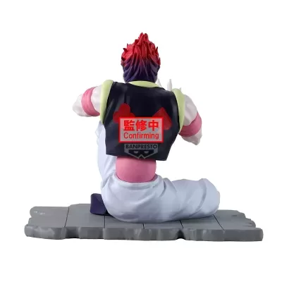 Figura colecionável de personagem sentado a mostrar as costas com colete preto e cabelo vermelho e roxo