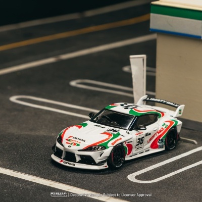 Carro de corrida de modelo branco com detalhes coloridos e logotipos num mini parque de estacionamento