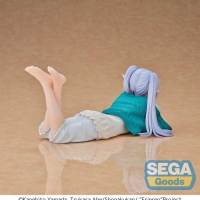 Figura anime deitada com cabelo lilás, colete azul e vestido branco sobre fundo bege.