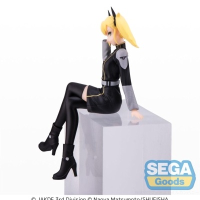 Figura colecionável de personagem feminina loira com roupa preta e cinza, sentada numa bancada cinza