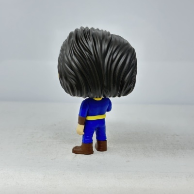 Figura vinil cabelo preto com roupa azul vista de costas