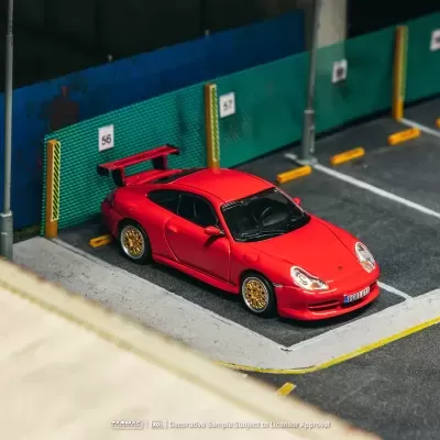 Modelo de carro desportivo vermelho com rodas douradas num parque de estacionamento