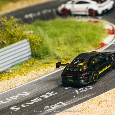Dois carros de brinquedo Porsche GT3 RS numa pista de corrida em miniatura