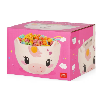 Tigela cerâmica branca com rosto de unicórnio cheia de cereais coloridos em caixa rosa