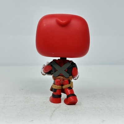 Figura de ação vermelha e preta vista de costas sobre fundo cinza