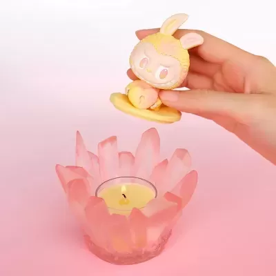 Vela em suporte rosa com figura decorativa de coelho amarela