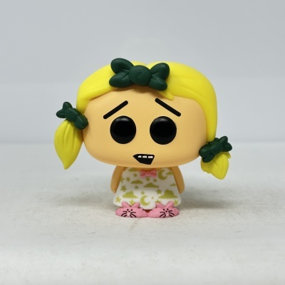 Figura Funko Pop com cabelo amarelo, olhos grandes pretos e pijama branco com padrões amarelos