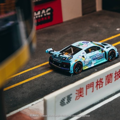 Miniatura de carro de corrida azul com decalques e número 36 em estrada com barreira branca e caracteres vermelhos