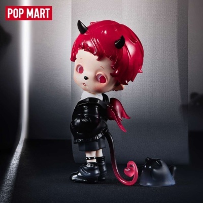 Figura de vinil de menino com cabelo vermelho e asas vermelhas sobre fundo cinzento