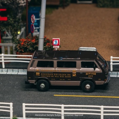 Miniatura de carrinha na estrada com texto dourado e sinais de trânsito