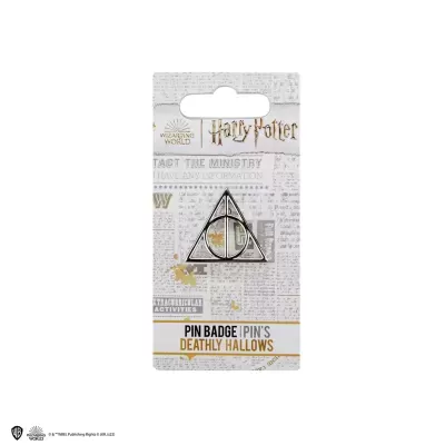 Pin metálico símbolo Deathly Hallows da Harry Potter em embalagem com padrão de jornal.