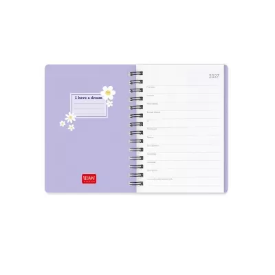 Agenda espiral lilás com flores brancas e amarelas e texto I have a dream aberta na página de dados pessoais com ano 2027.